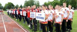 Drużyny uczestniczące w zawodach stoją na płycie boiska podczas rozpoczęcia. Na pierwszym planie reprezentacja Centralnej Szkoły PSP w Częstochowie.