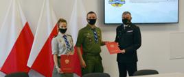 Pomorski komendant wojewódzki Państwowej Straży Pożarnej oraz komendant, skarbnik Związku Harcerstwa Polskiego Chorągiew Gdańska trzymają podpisane porozumienie.
