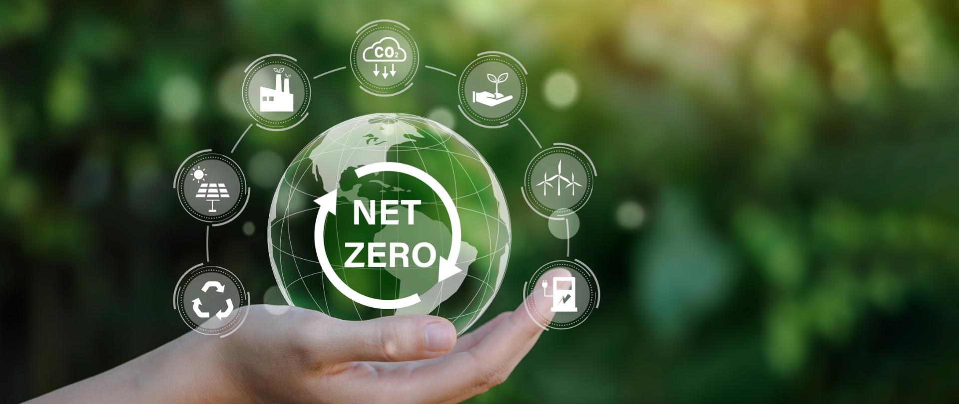Net zero icon and carbon neutral concept in the hand for net zero greenhouse gas emissions target Climate neutral long term strategy on a green background.