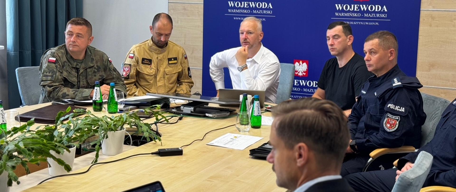 Grupa Osób siedzi przy stole 