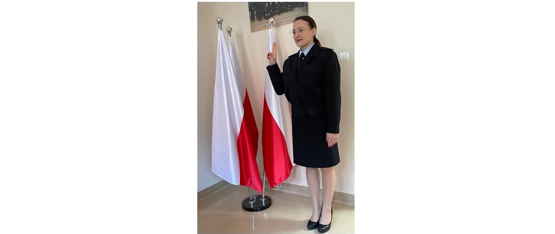Uroczyste Ślubowanie strażaka Renata Łakomy odbyło się w gabinecie Pana p.o. Komendanta PSP w Wołominie st. bryg. mgr inż. Bogusława Majchrzak w tle stojak z trzema flagami biało-czerwonymi. 