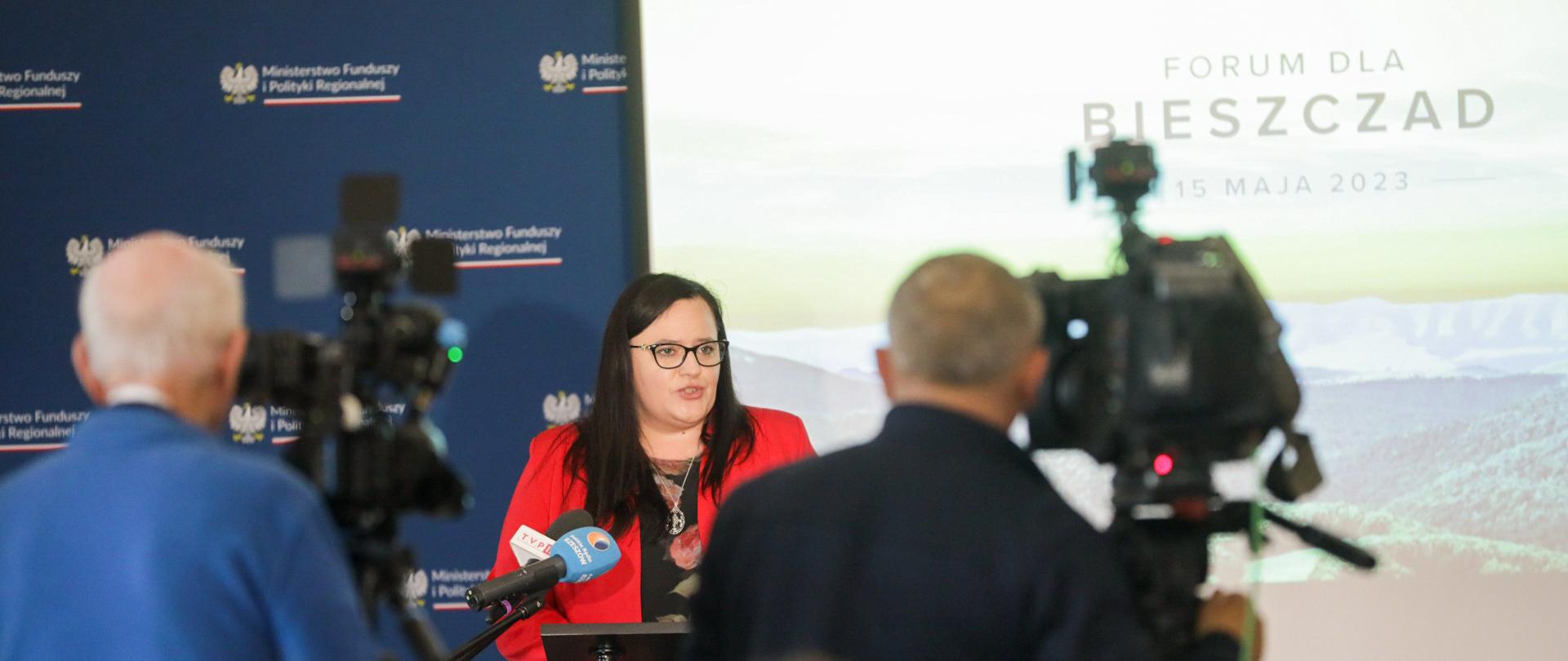 Wiceminister Małgorzata Jarosińska-Jedynak przed mikrofonami i kamerzystami na tle ścianki MFiPR