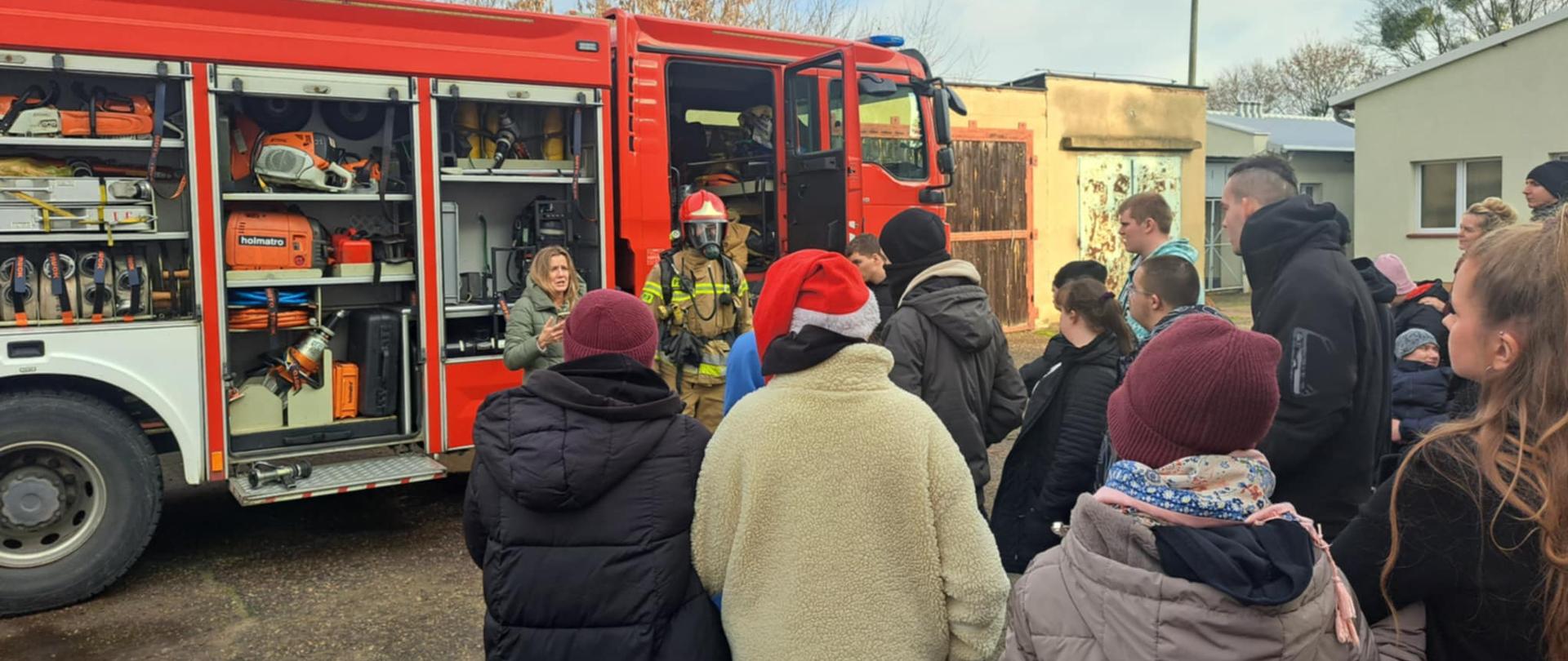 Grupa młodzieży oglądająca sprzęt strażacki