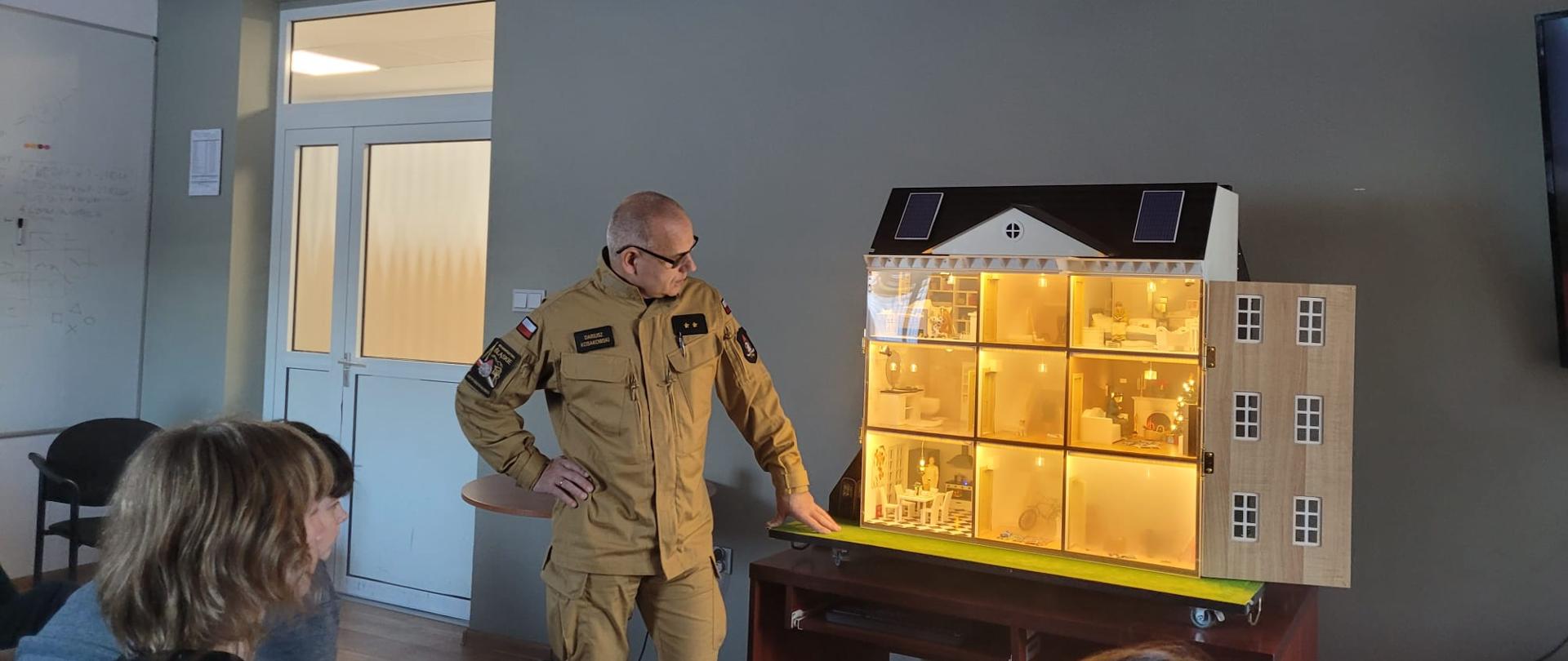 Strażak prezentuje symulację pożaru na mobilnym symulatorze zagrożeń.