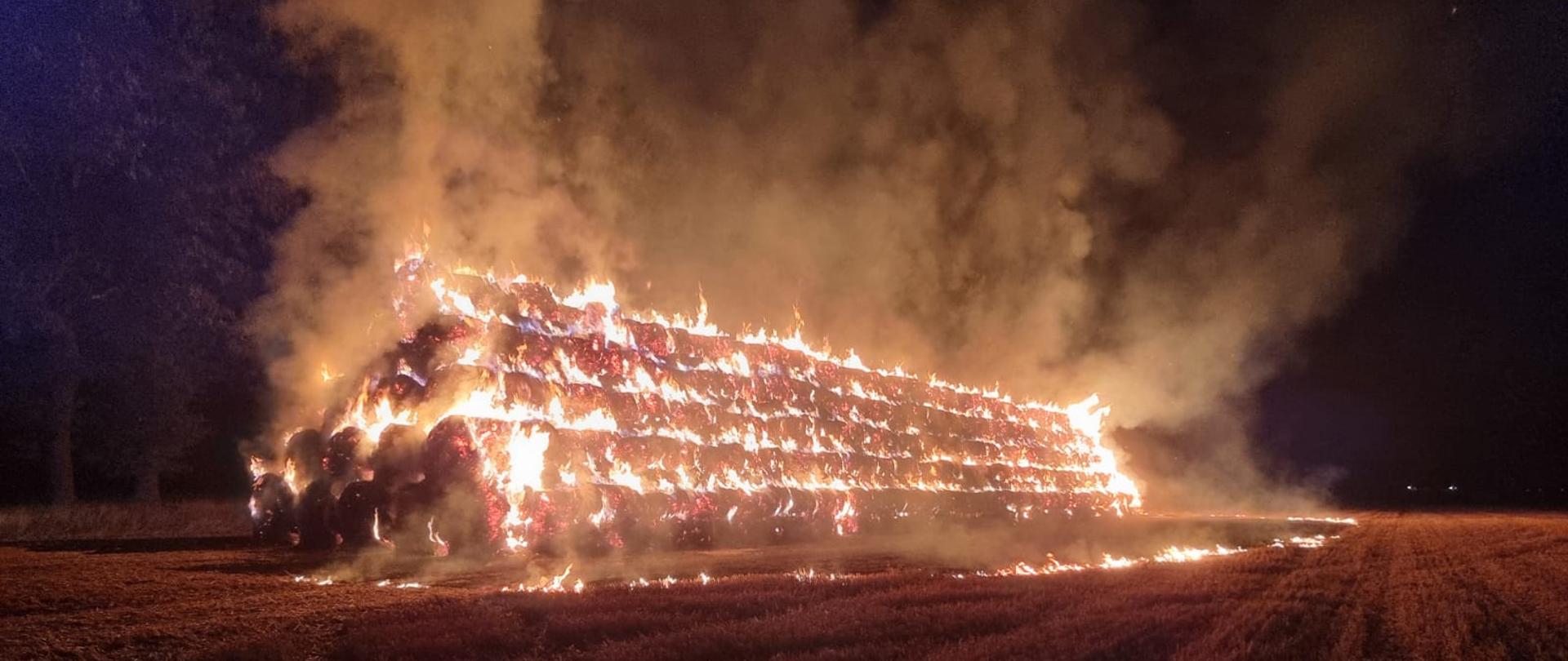 Jest pora nocna. Na zdjęciu widać całkowity pożar stogu składającego się z kilkuset balotów słomy