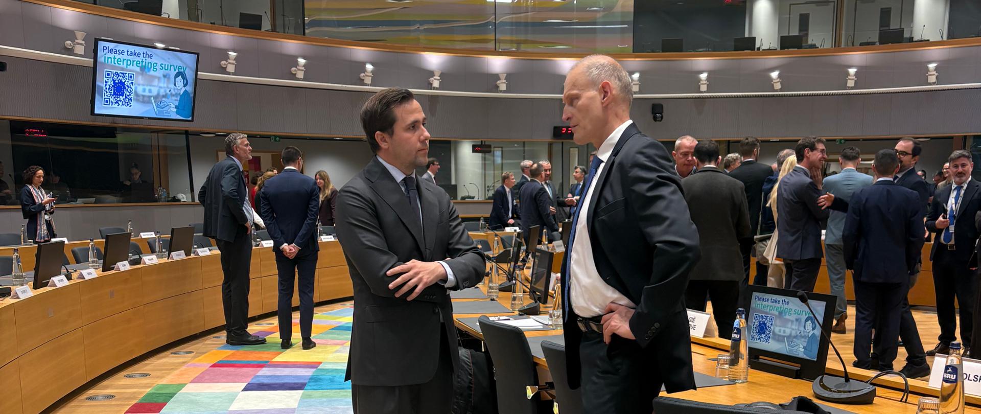 Dwóch mężczyzn rozmawia w okrągłej sali konferencyjnej, jeden z nich to Podsekretarz Stanu Wojciech Jabłoński 