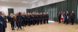 pododdziały stoją na sali gimnastycznej podczas Obchodów Powiatowego Dnia Strażaka