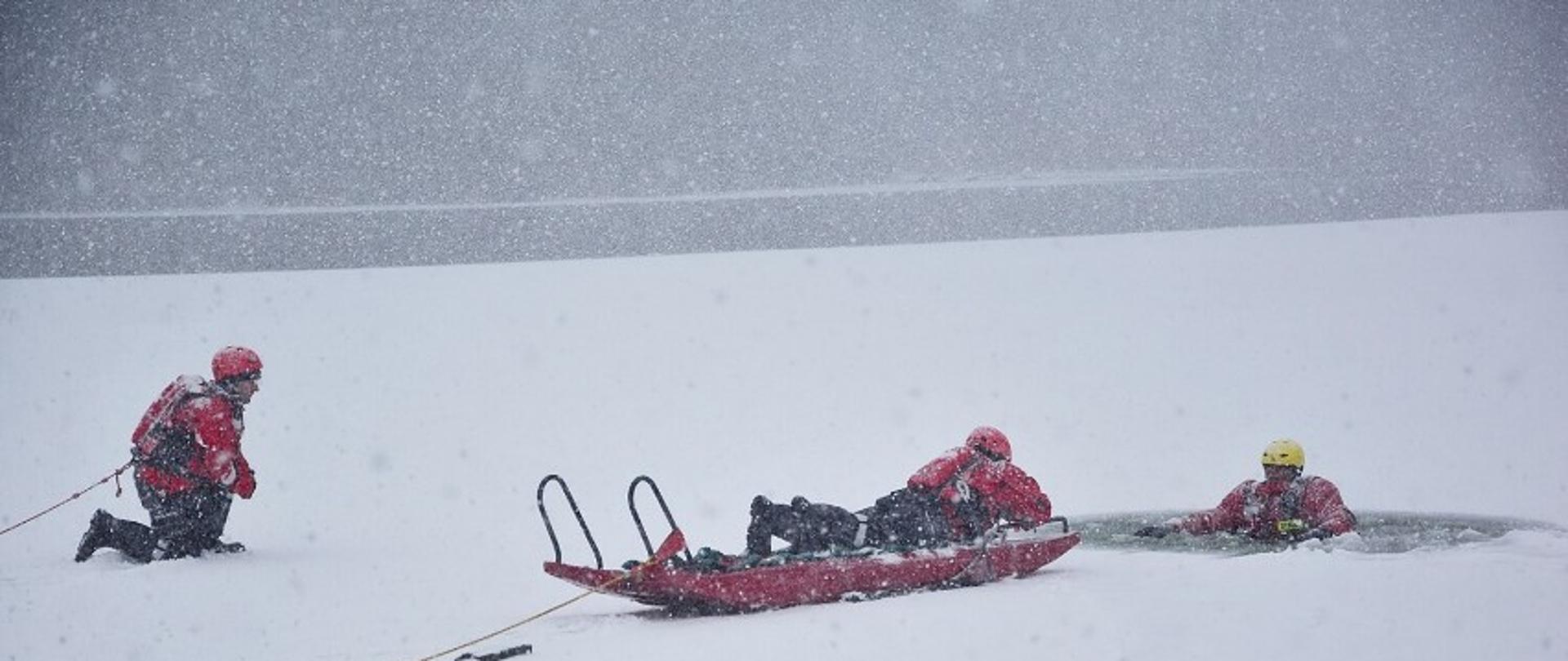 Strażacy znajdują na pokrywie lodowej i w przeręblu wyposażeni w sprzęt ratowniczy i asekuracyjny