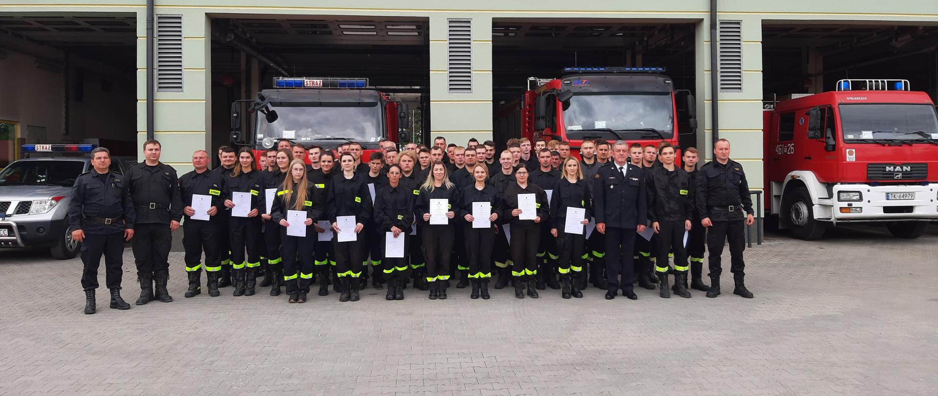 Strażacy stojący przed budynkiem Komendy Powiatowej PSP w Pińczowie