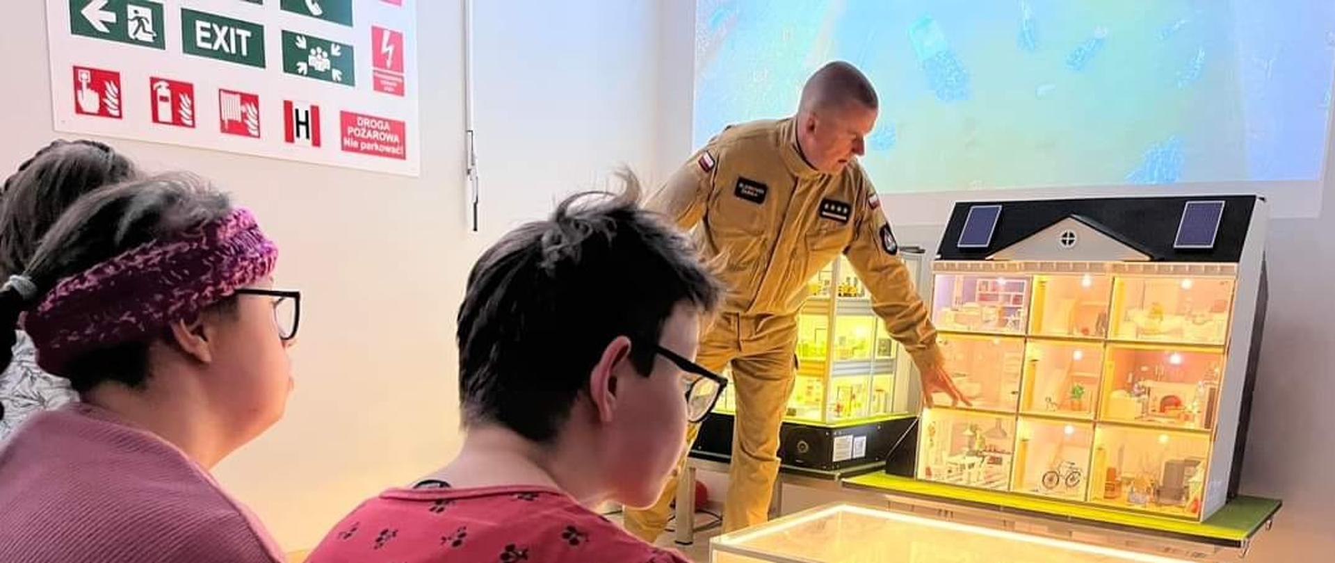 Strażak i osoby cywilne w pomieszczeniupłomyczka.