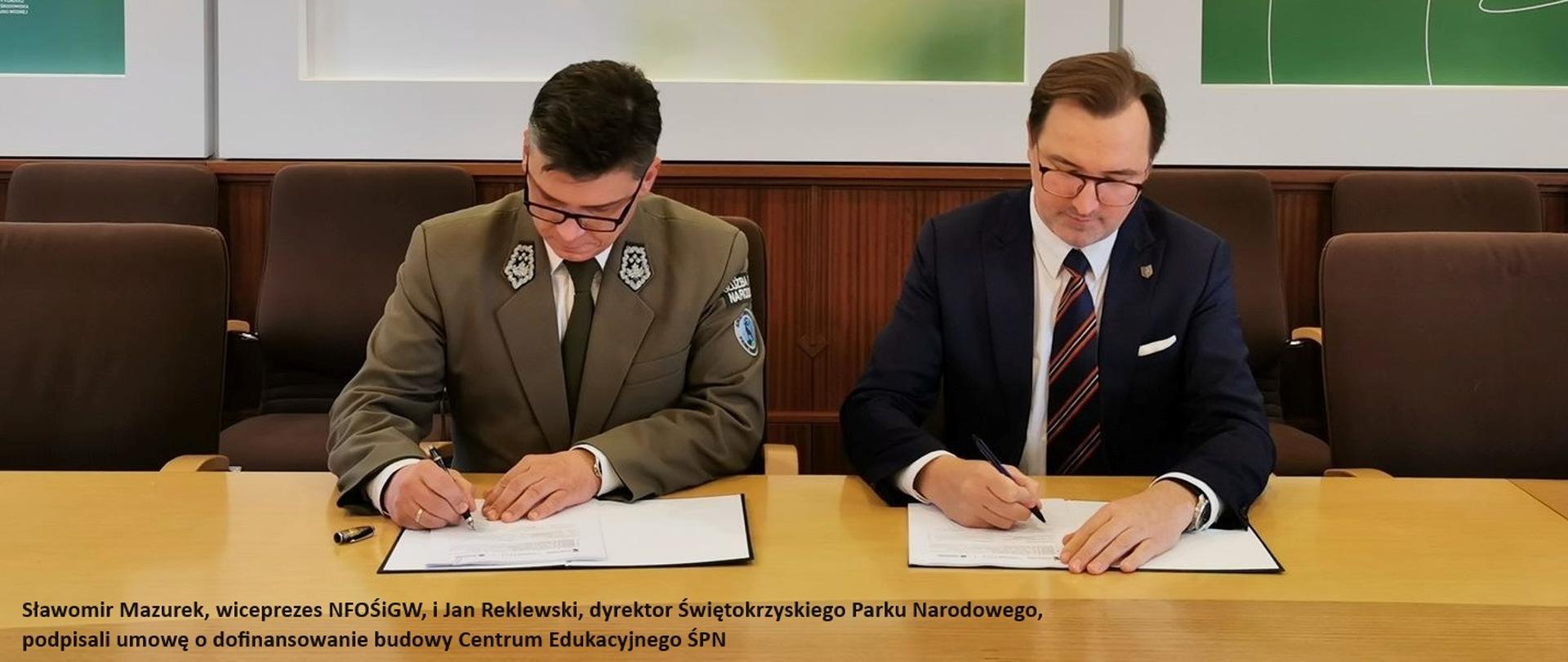 Stół przy którym dwóch urzędników, przedstawicieli Narodowego Funduszu Ochrony Środowiska i Gospodarki Wodnej oraz Świętokrzyskiego Parku Narodowego podpisuje dwa egzemplarze umowy o dofinansowanie projektu.