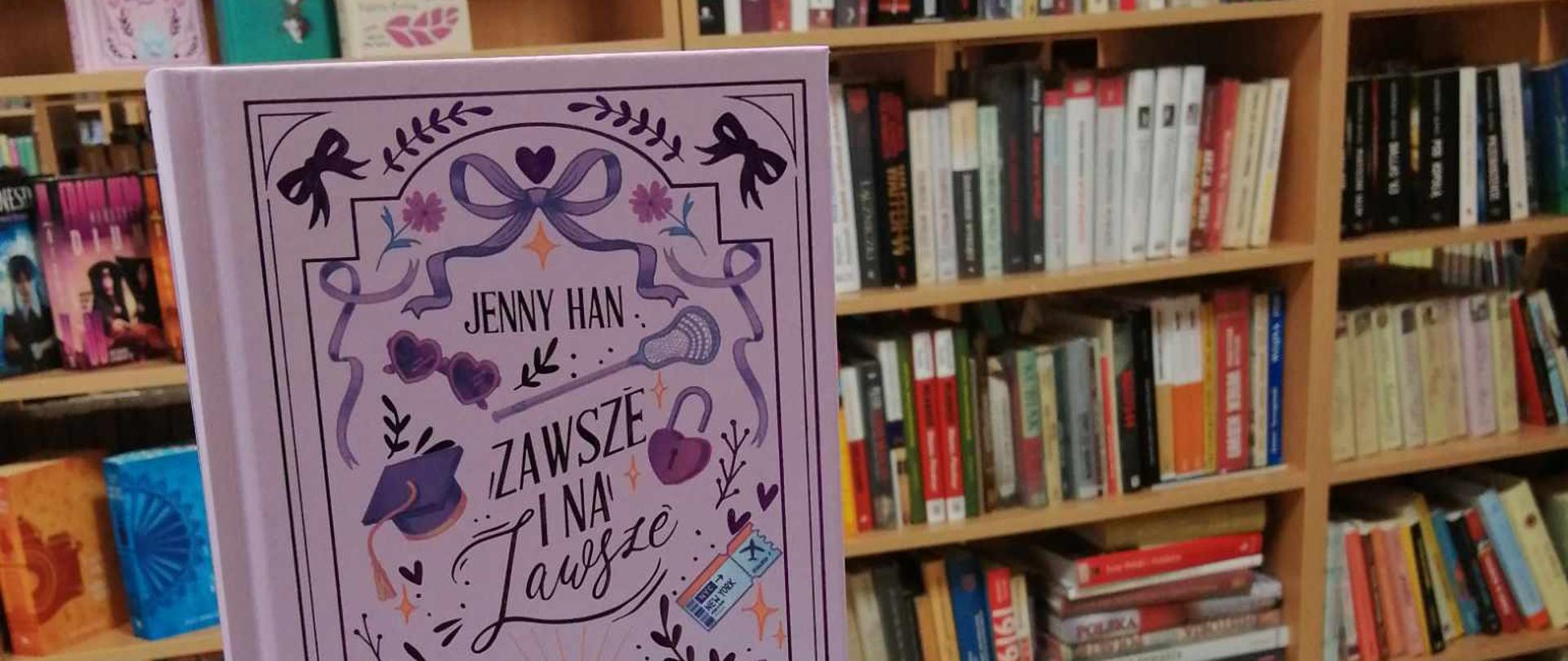 Kilka książek prezentowanych na tle regałów bibliotecznych