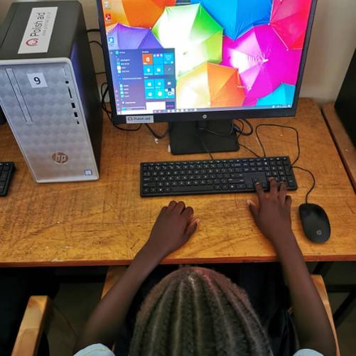 Młoda uczennica podczas swojej pierwszej lekcji obsługi komputera.