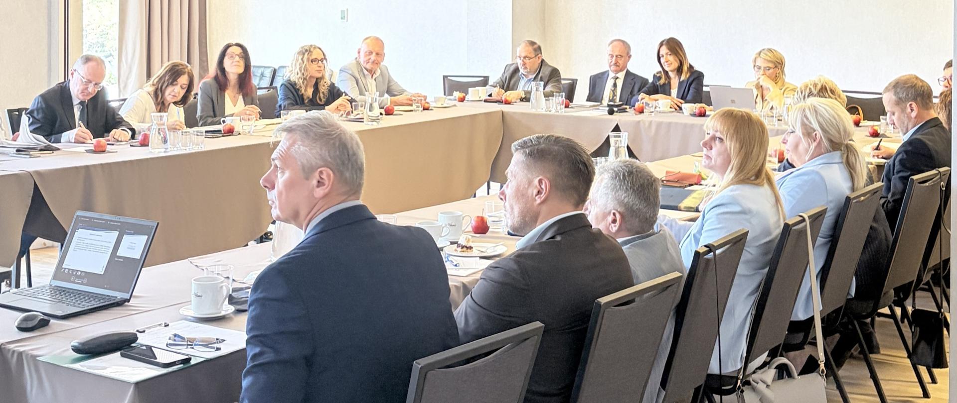 Grupa osób siedząca przy stole konferencyjnym