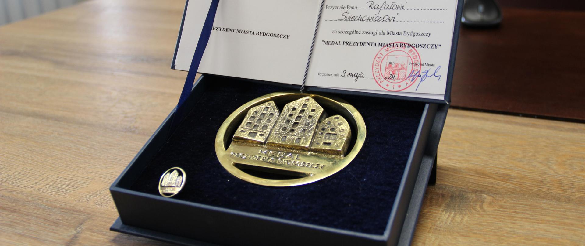 Medal Prezydenta Bydgoszczy - w granatowym etui. Leży na stole.