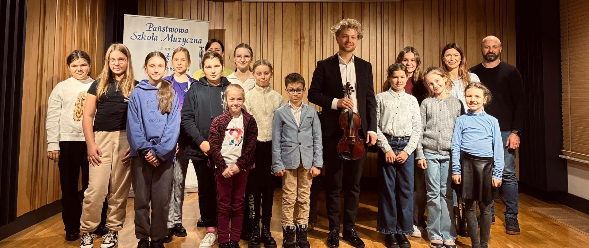 Grupa skrzypków na scenie sali koncertowej PSM