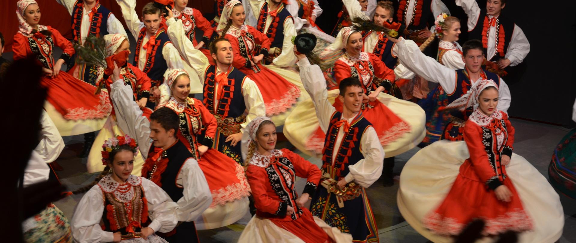 Pary w strojach ludowych tańczącze krakowiaka