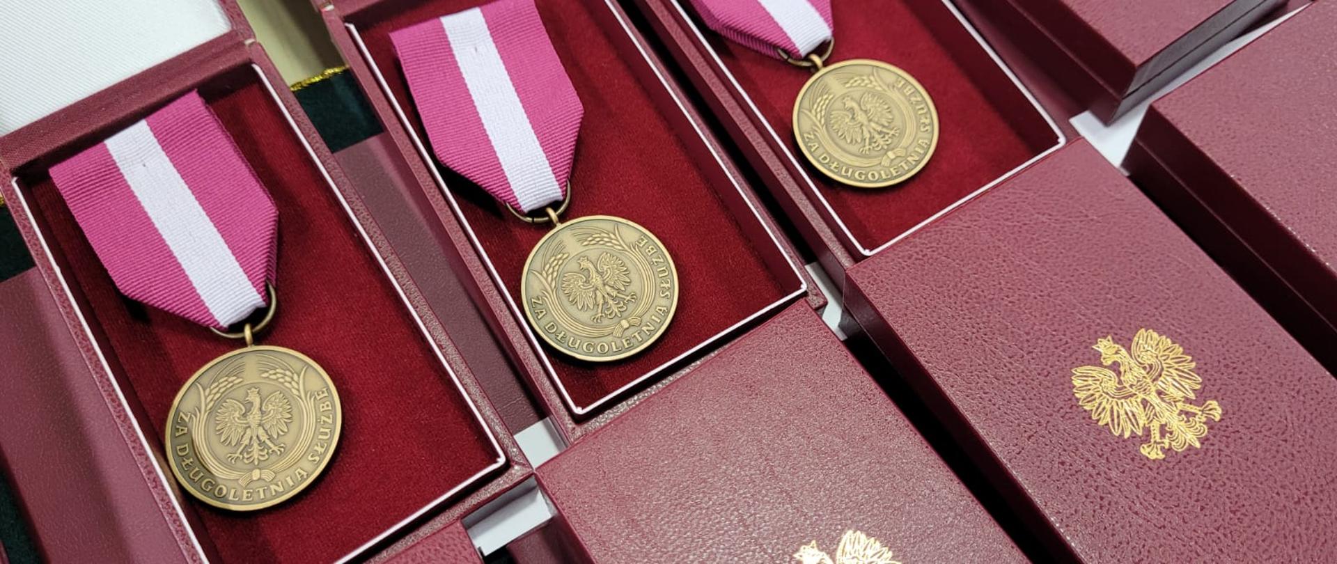 Na stole ułożone odznaczenia państwowe medale brązowy „Medal za długoletnią służbę”.
