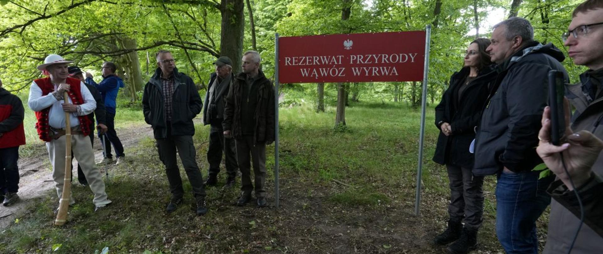 Uroczyste otwarcie rezerwatu przyrody Wąwóz Wyrwa. Grupa osób przy tablicy z napisem rezerwat przyrody Wąwóz Wyrwa