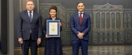 Kobieta i dwóch mężczyzn pozują do zdjęcia