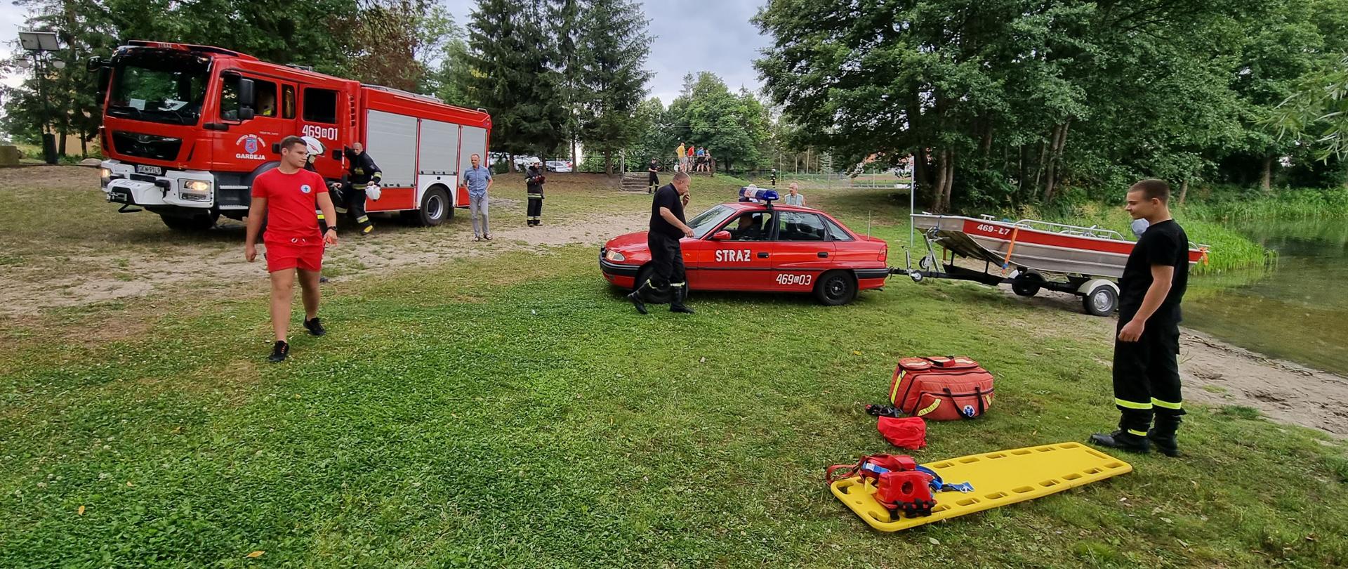 Pojazdy ratownicze OSP Gardeja wraz z łodzią nad jeziorem Kamień