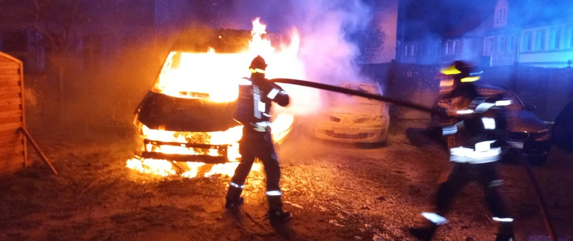 strażacy gaszą palący się pojazd.