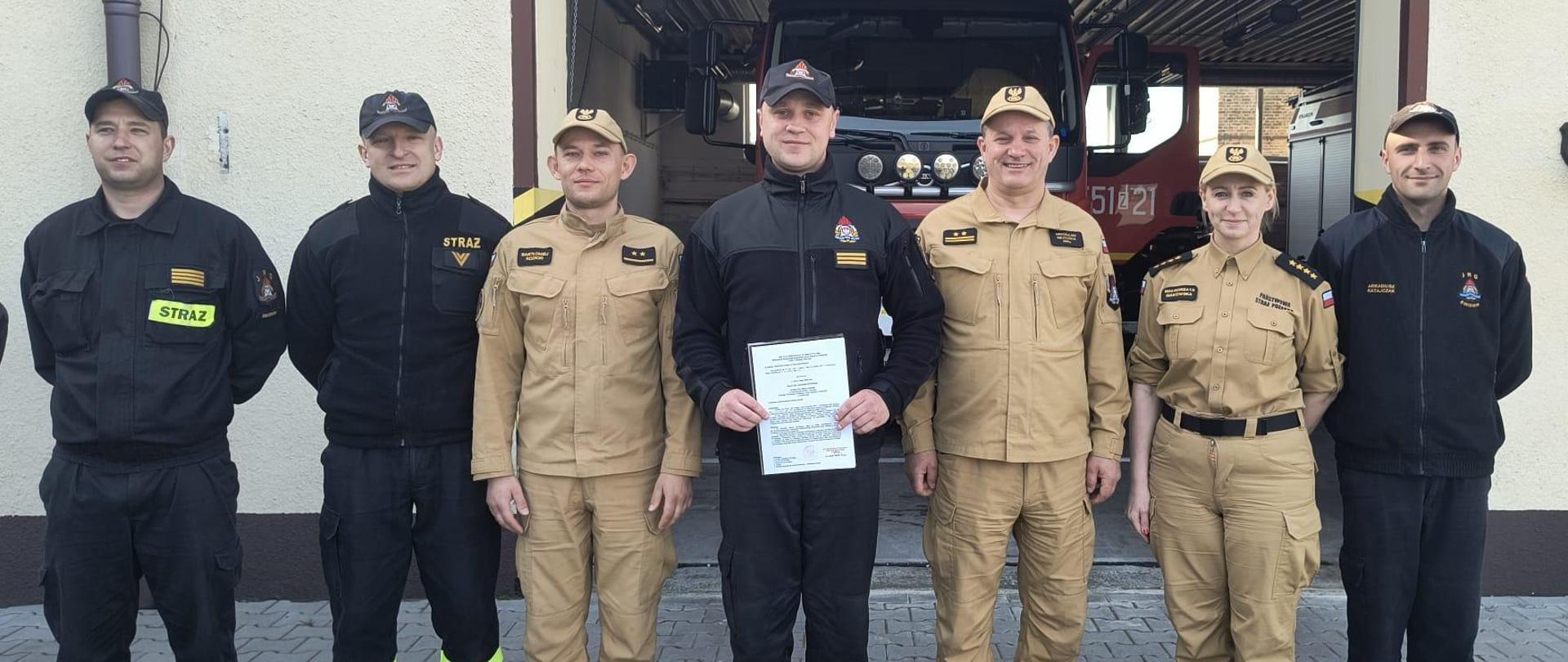 Zdjęcie przedstawia wręczenia aktu mianaowania na wyzsze stanowisko na placu JRG