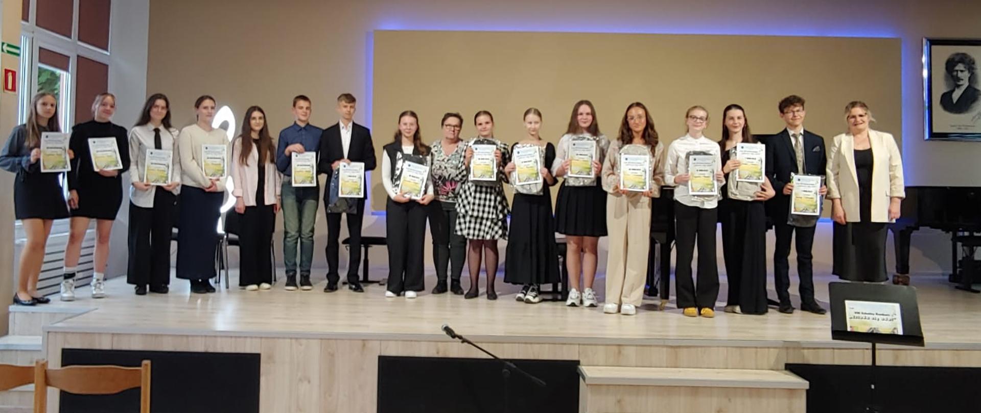 na scenie nagrodzeni uczniowie z dyplomami