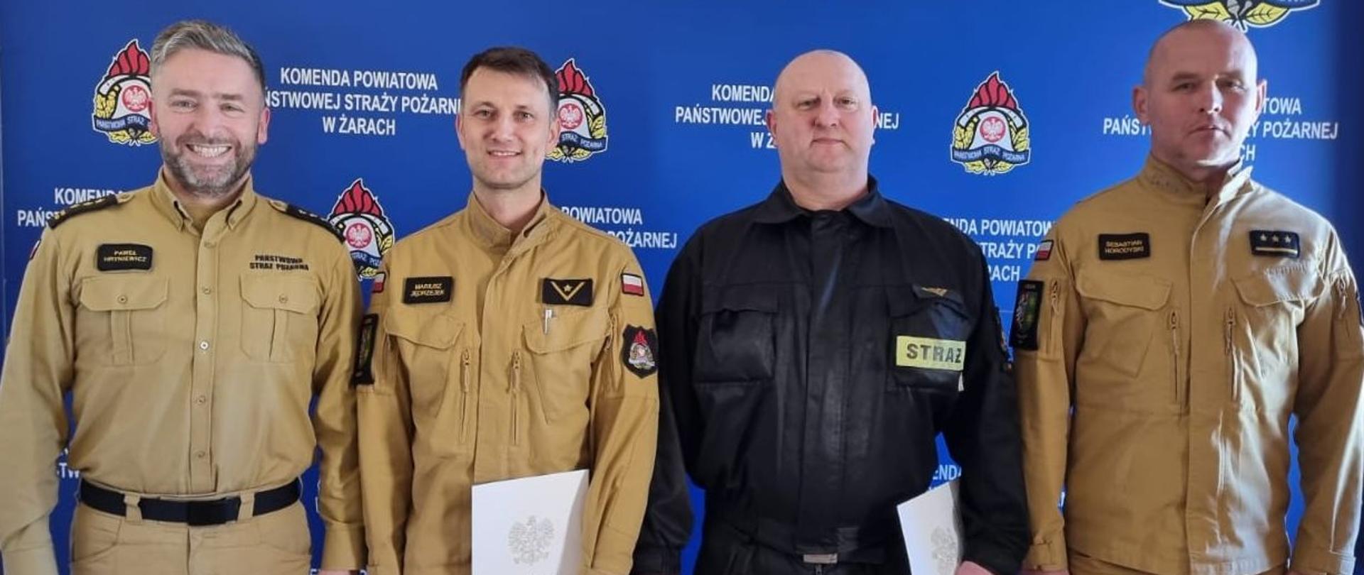 Na zdjęciu widoczni są strażacy otrzymujący nagrodę z Komendantem i Dowódcą JRG 