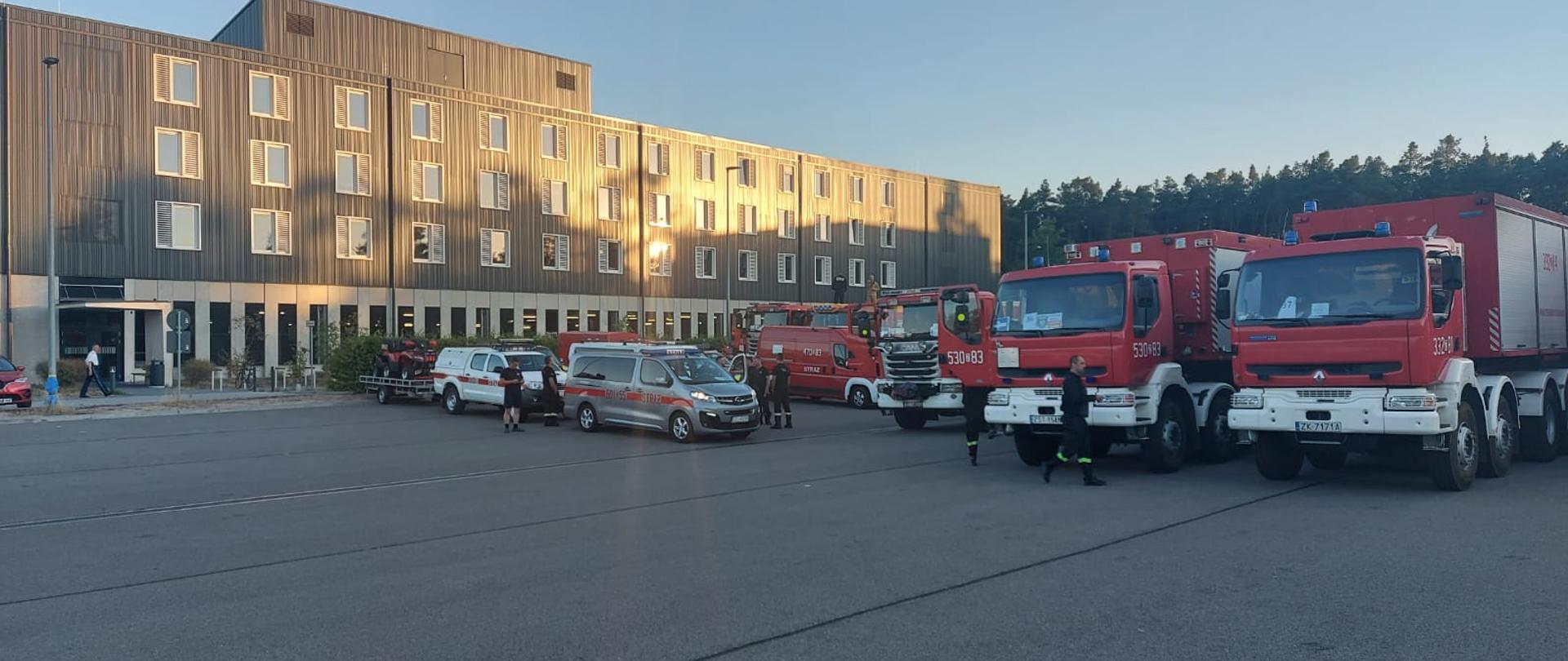 Ustawione w rzędzie samochody strażackie na tle budynku Straży Pożarnej we Francji