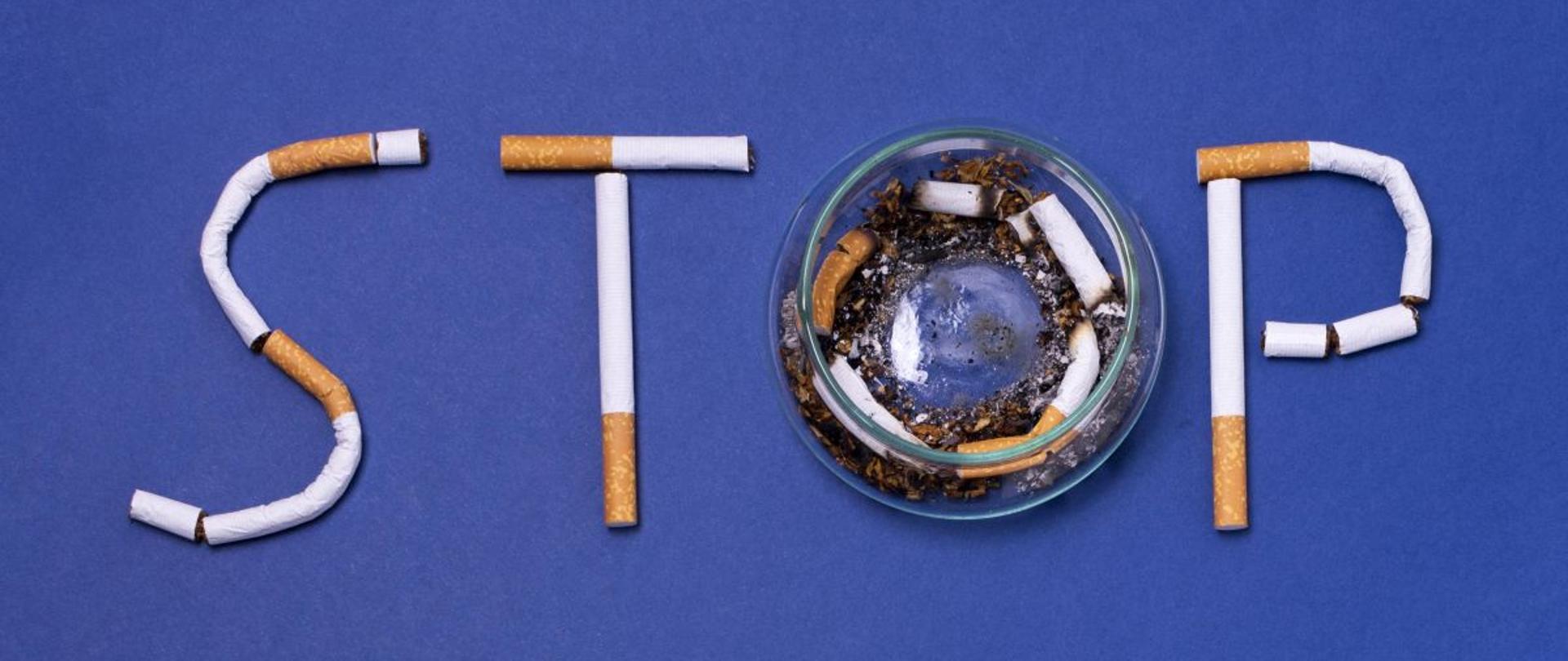 Zdjęcie przedstawia napis Stop ułożony z papierosów, gdzie literka o to popielniczka