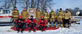 Zdjęcie grupowe strażaków nad zbiornikiem wodnym podczas ćwiczeń z ratownictwa lodowego