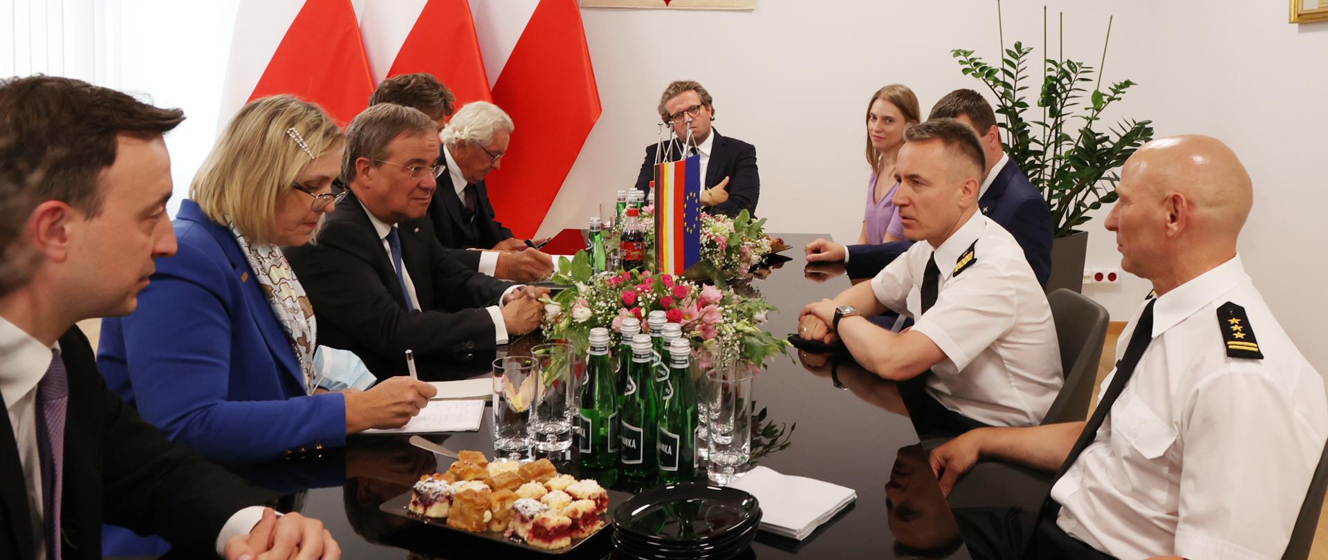 Delegacja Niemiecka i delegacja polska w czasie spotkania. W tle godło i flagi narodowe