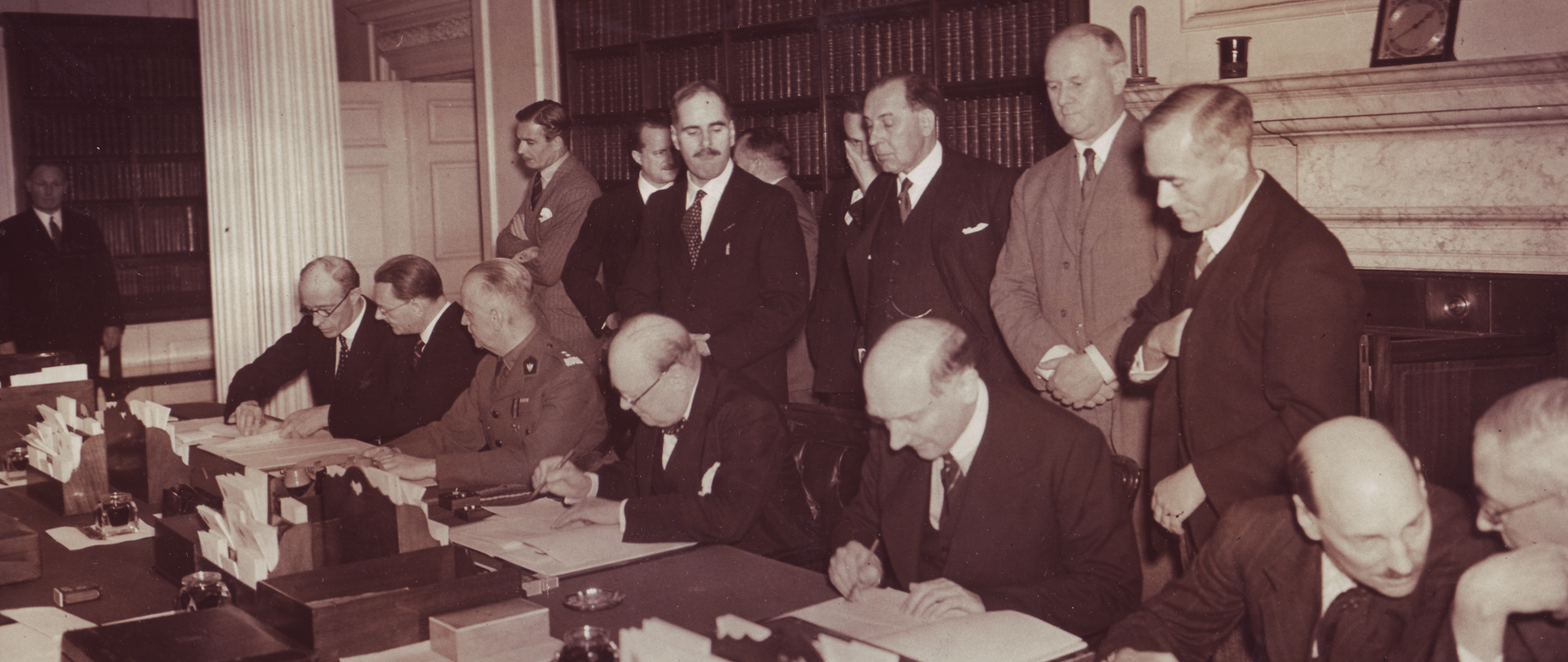 The signing of the Anglo-Polish military alliance. Seated from the left are: Foreign Secretary Lord Halifax, Ambassador Edward Raczyński, Prime Minister General Władysław Sikorski, Prime Minister Winston Churchill, Foreign Minister August Zaleski and members of Britain’s War Cabinet Clement Attlee and Arthur Greenwood. In the background: War Secretary Anthony Eden (standing behind Sikorski) and Home Secretary John Anderson (standing behind Churchill). Secretary for Dominion Affairs Thomas Inskip stands behind FM Zaleski.
