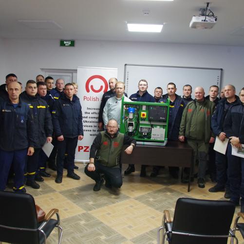 Zdjęcie przedstawia grupę uczestników szkolenia personelu DSNS, w tle baner z logo Polska pomoc