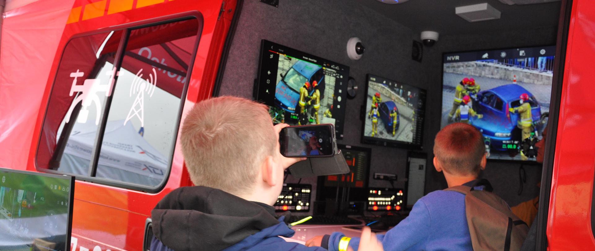 Dzieci zwiedzają samochód pożarniczy do obsługi naziemnej dronów