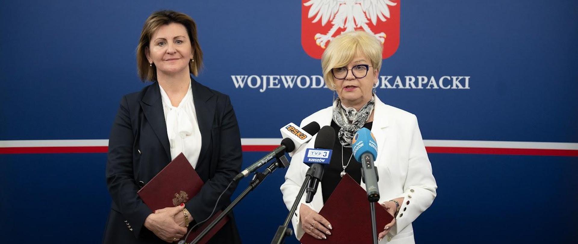 Wojewoda podkarpacki Teresa Kubas-Hul zabiera głos podczas konferencji prasowej. Po lewej stronie dyrektor Wydziału Polityki Społecznej Podkarpackiego Urzędu Wojewódzkiego w Rzeszowie Irena Marszałek-Czekierda 