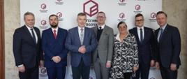W korytarzu pod ścianą z napisem Politechnika Bydgoska stoi minister Wieczorek i sześć osób.