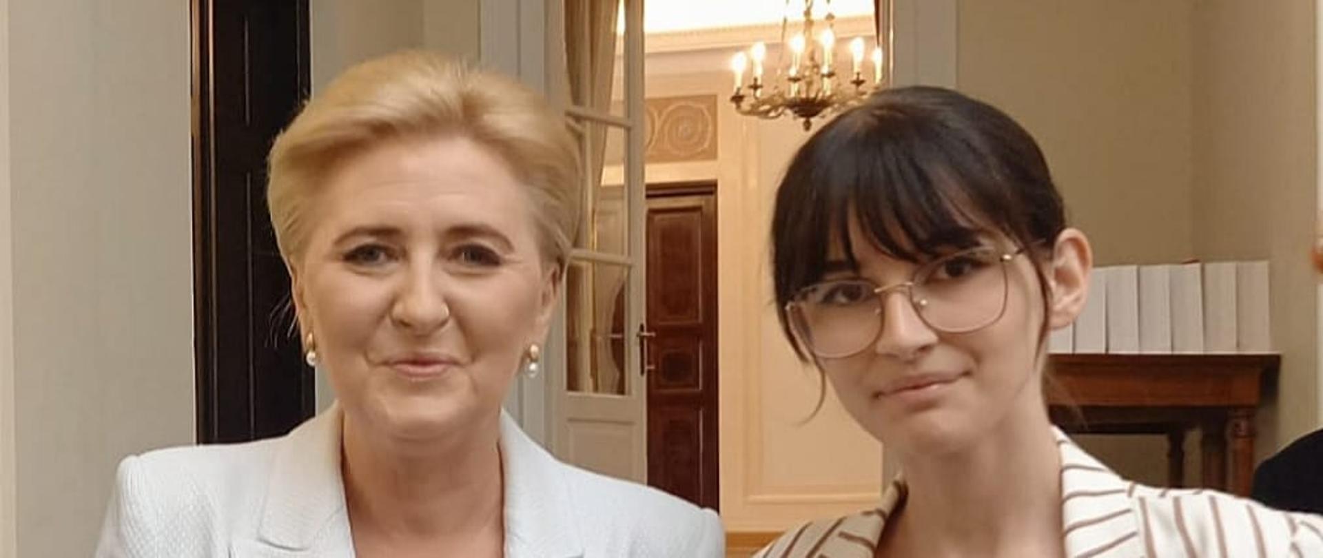 Dwie kobiety elegancko ubrane lekko uśmiechają się 