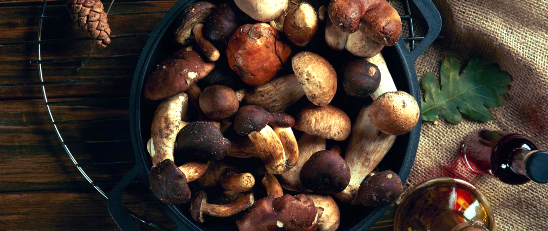 Na zdjęciu znajdują się grzyby w rondlu, są na stole.