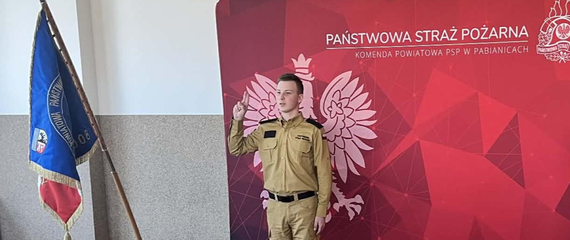 Na zdjęciu prowadzący uroczystą zbiórkę funkcjonariusz PSP podczas aktu ślubowania przez nowo zatrudnionego funkcjonariusza.