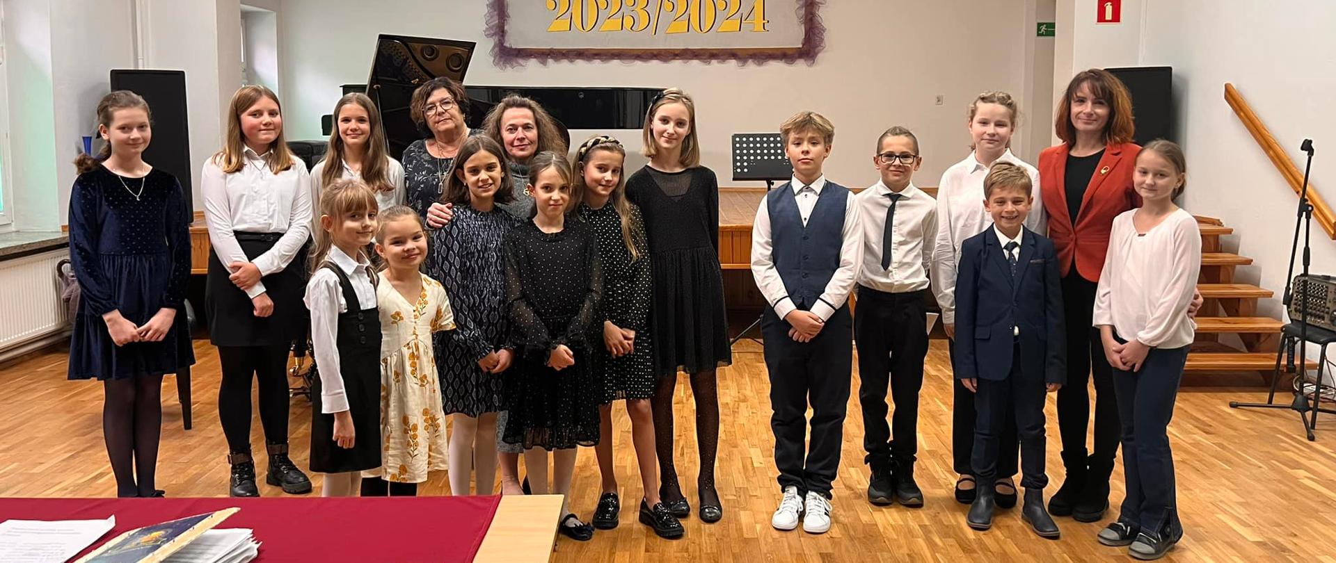 Zdjęcie przedstawiające wszystkich uczestników koncertu technicznego klas fortepianu w dniu 30 października 2023 roku w auli szkoły.
