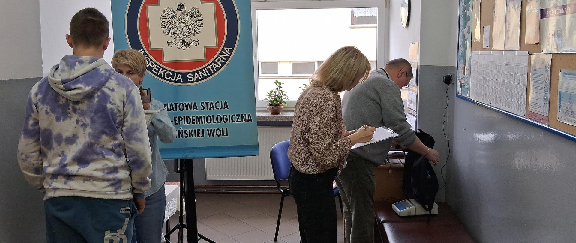 Pracownicy PSSE ważą plecaki w SP Nr 12 w Zduńskiej Woli