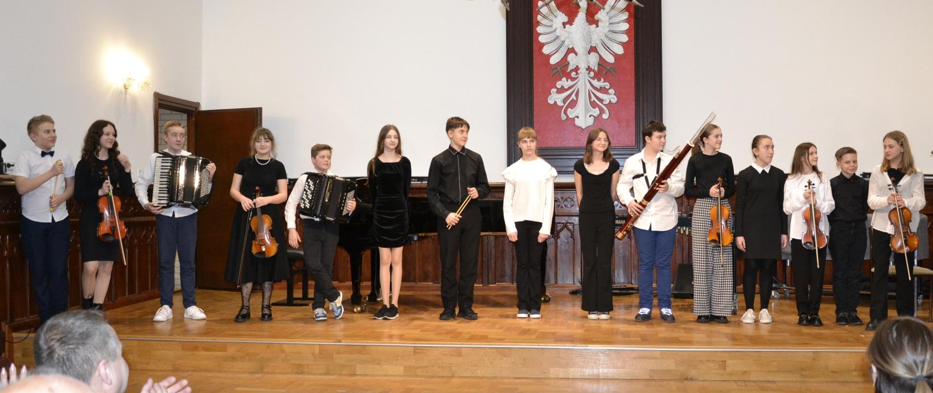 uczniowie klasy piątej cyklu sześcioletniego PSM I stopnia podczas swojego koncertu klasowego na scenie w Sali Królewskiej PSM Mielec