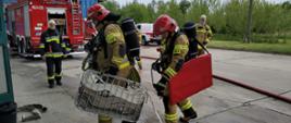 Widoczni strażacy podczas ćwiczeń z działań gaśniczych.