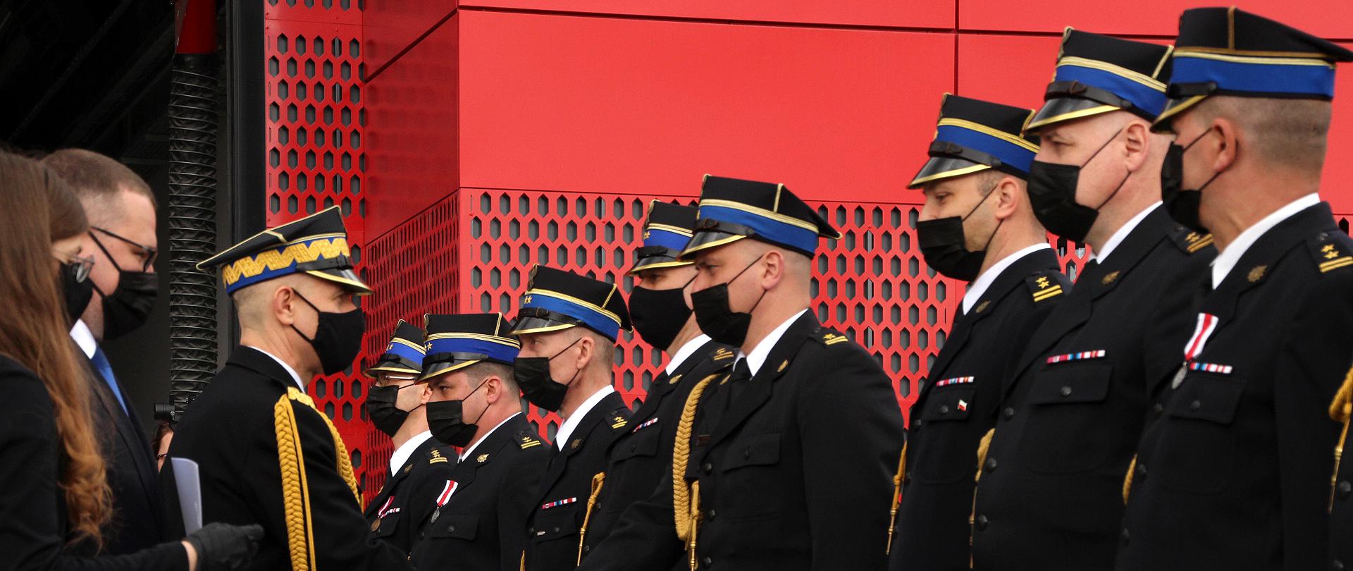 Na fotografii strażakom wręczane są awanse.