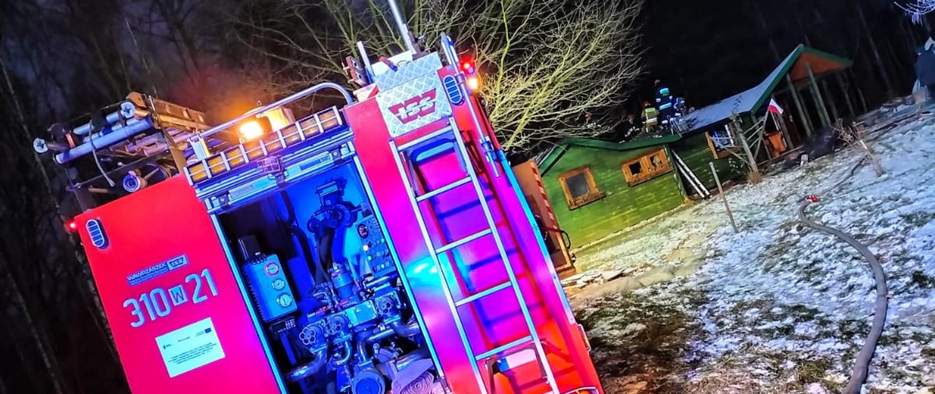 Na pierwszym planie widać wóz ratowniczo gaśniczy Renault będący na wyposażeniu JRG 10 w Warszawie. Na drugim planie widać rozwiniętą linię wężową biegnąca na miejsce działań strażaków