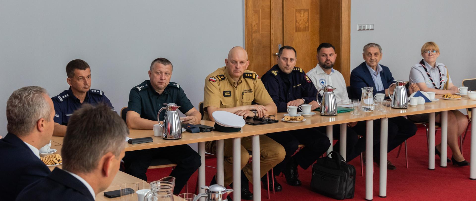 Uczestnicy narady siedzą przy stole.