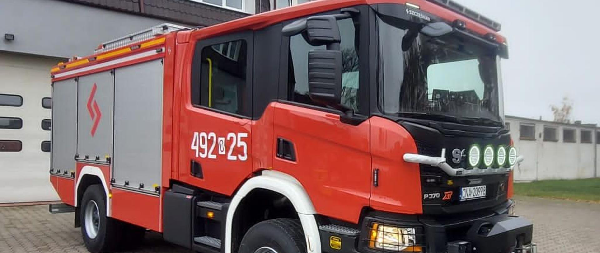 Na zdjęciu ciężki samochód ratowniczo-gaśniczy. Ujęcie przodu i prawego boku. 