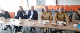 W sali konferencyjnej siedzą przedstawiciele zarządu OSP wraz z funkcjonariuszami PSP